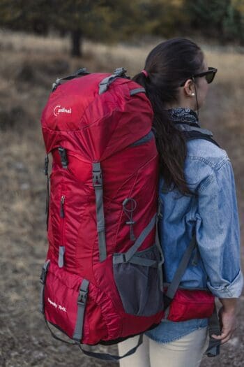 Σακίδιο πλάτης ορειβατικό σε κόκκινο χρώμα με γυναίκα να κάνει εξόρμηση στο βουνό