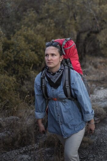Σακίδιο πλάτης ορειβατικό σε κόκκινο χρώμα με γυναίκα να κάνει εξόρμηση στο βουνό